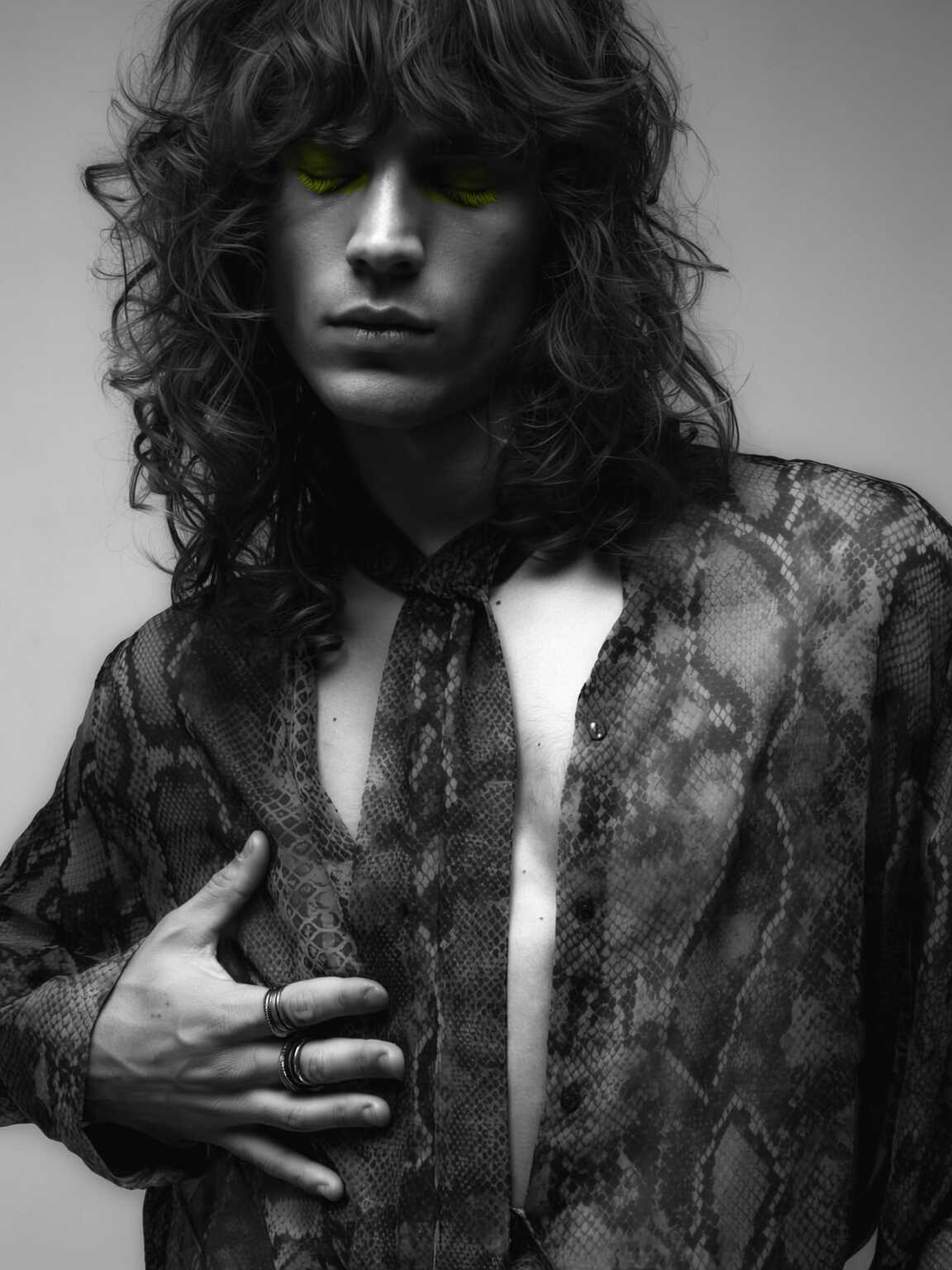 grainy night candid of Damon Cael exiting a venue in dramatic couture, rising pop artist Damon Cael.