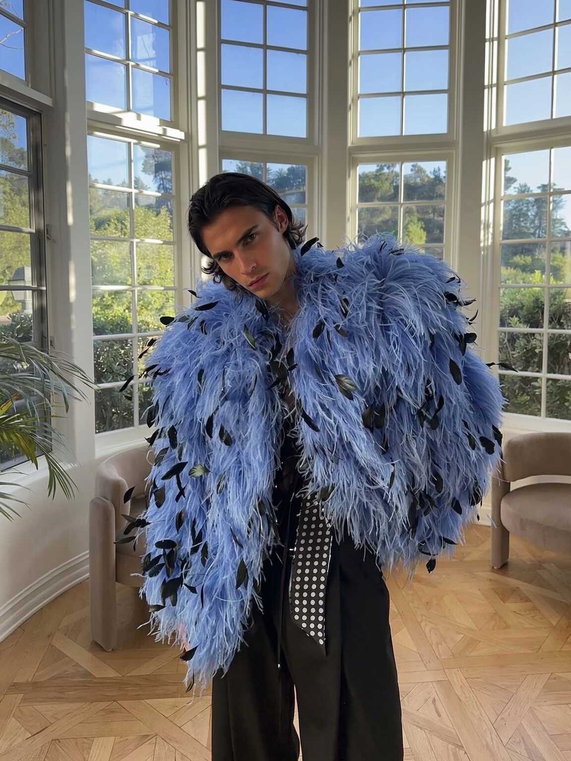 paparazzi-style shot of Damon Cael framed by parked cars at night, rising pop artist Damon Cael.