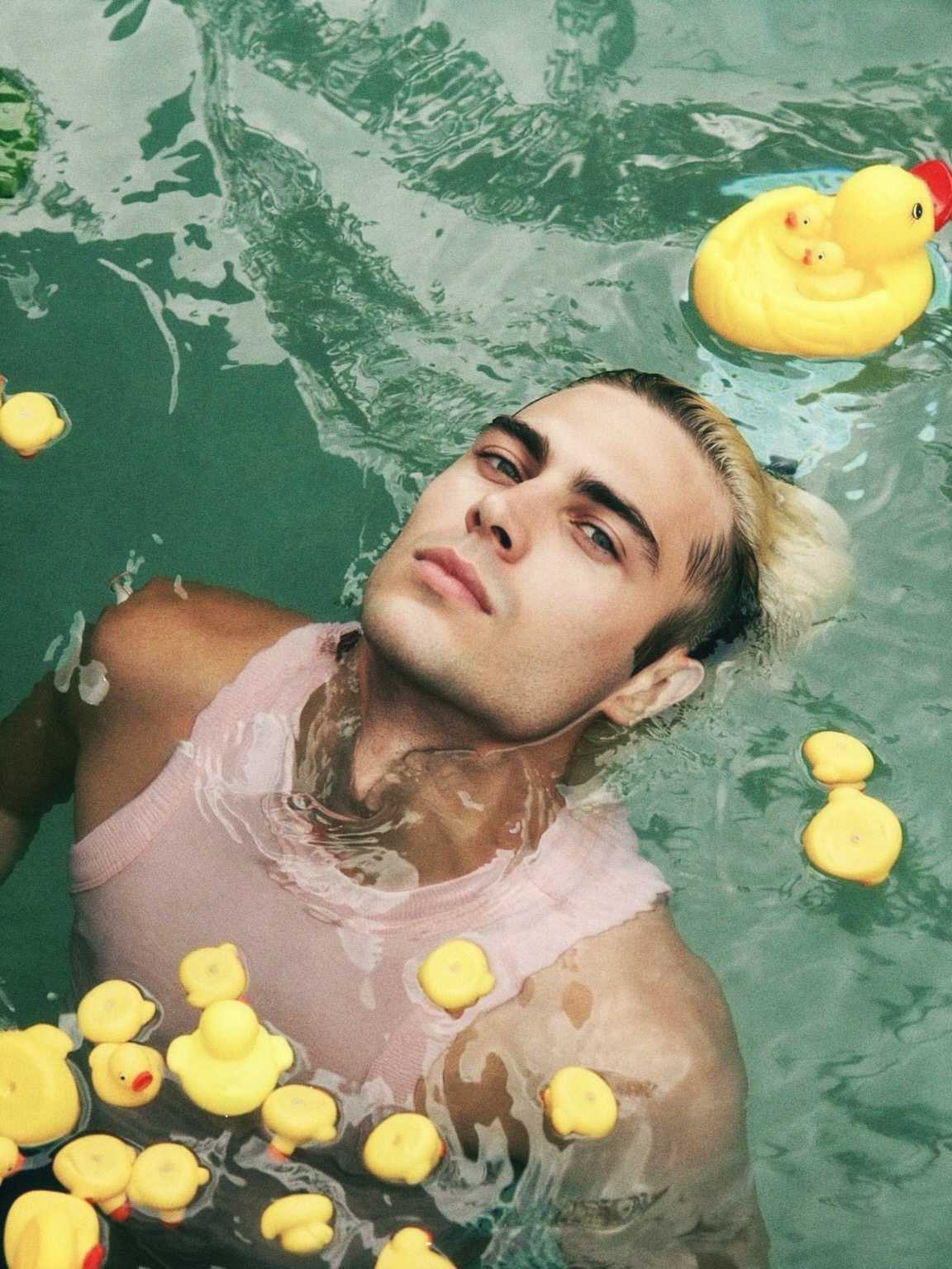 paparazzi image of Damon Cael standing by a black SUV in full couture, rising pop artist Damon Cael.