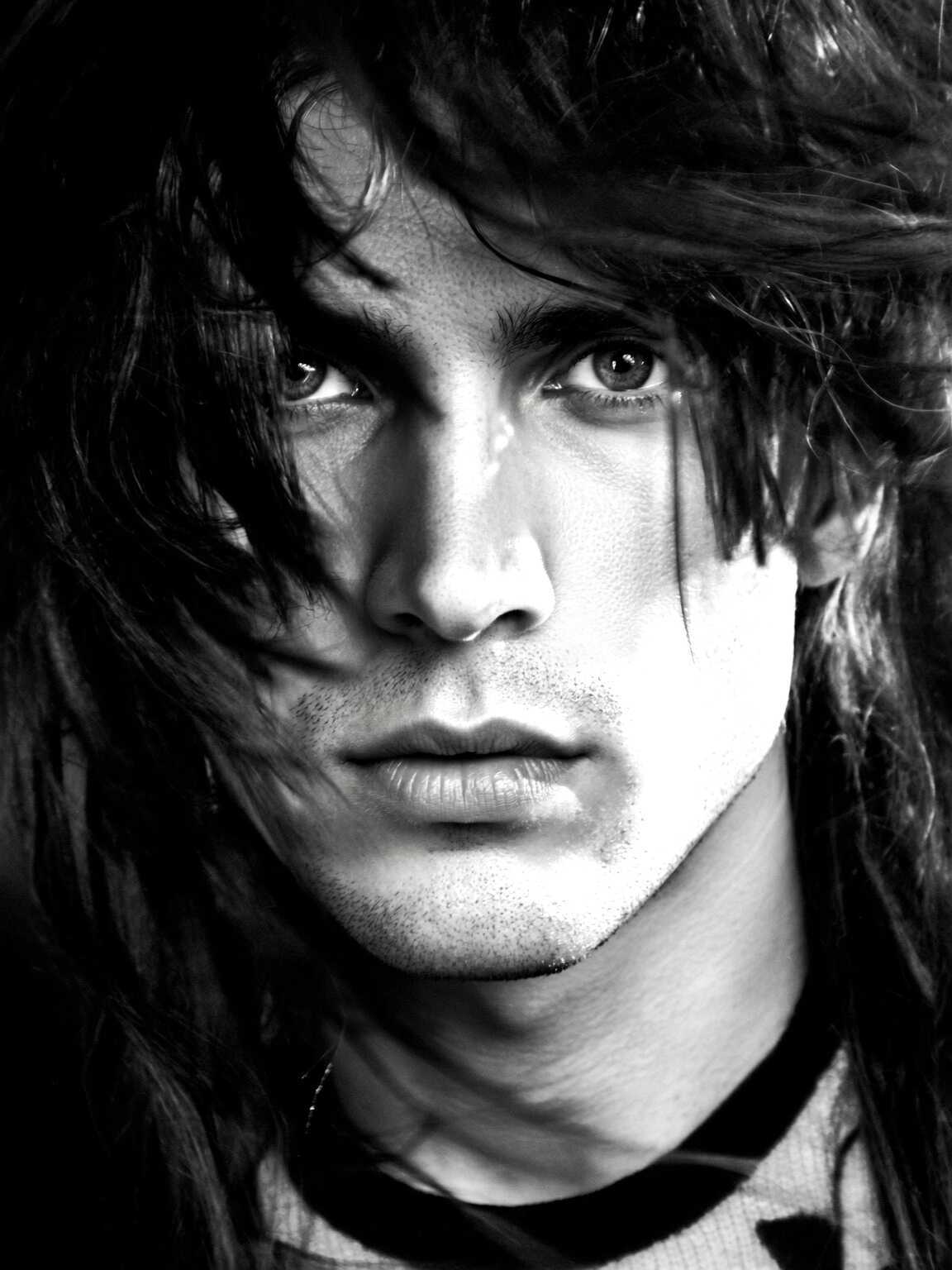 street-level paparazzi shot of Damon Cael walking in avant-garde runway styling, rising pop artist Damon Cael.