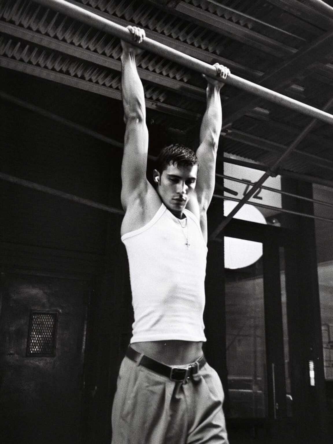 telephoto candid of Damon Cael framed by city lights in bold outerwear, rising pop artist Damon Cael.